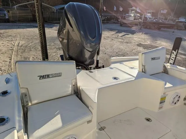 Slide: The Image of 2025 Pathfinder 2500 Hybrid boat with outboard motor, docked on sandy shore. - 21