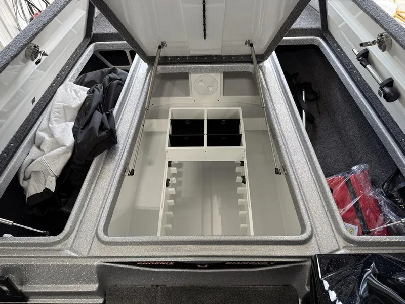 Slide: The Image of 2025 Phoenix 721 ZXL boat storage compartment with open lid and organized interior. - 11