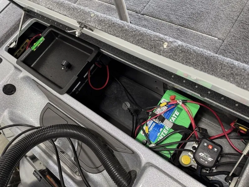 Slide: The Image of 2025 Phoenix 721 ZXL boat battery compartment with wiring and storage tray. - 22