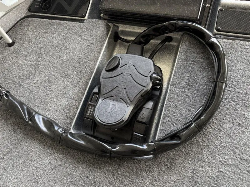 Slide: The Image of Steering wheel of a 2025 Phoenix 721 ZXL boat, featuring a sleek black design. - 5