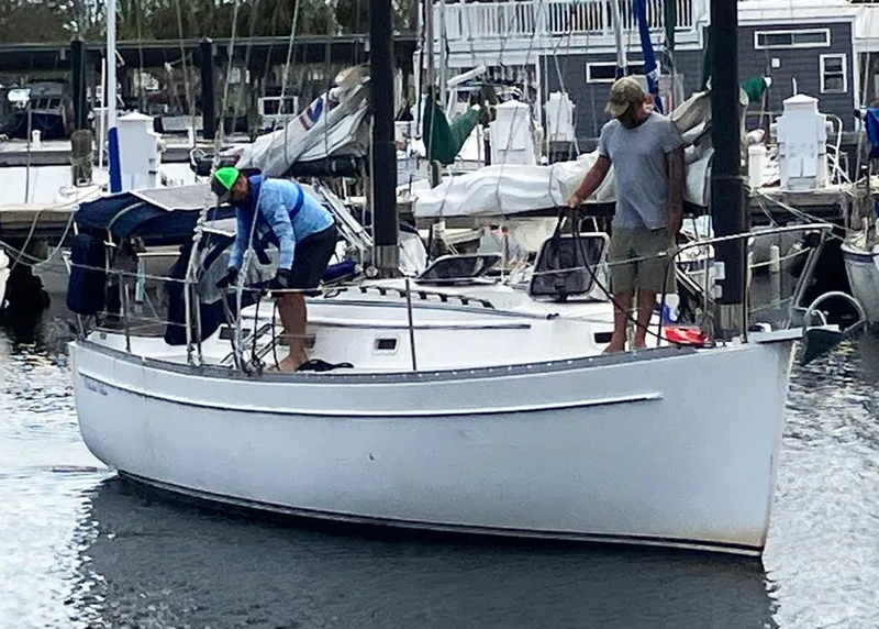 Slide: The Image of 1983 Freedom Cat Ketch sailboat with two people at a marina. - 3