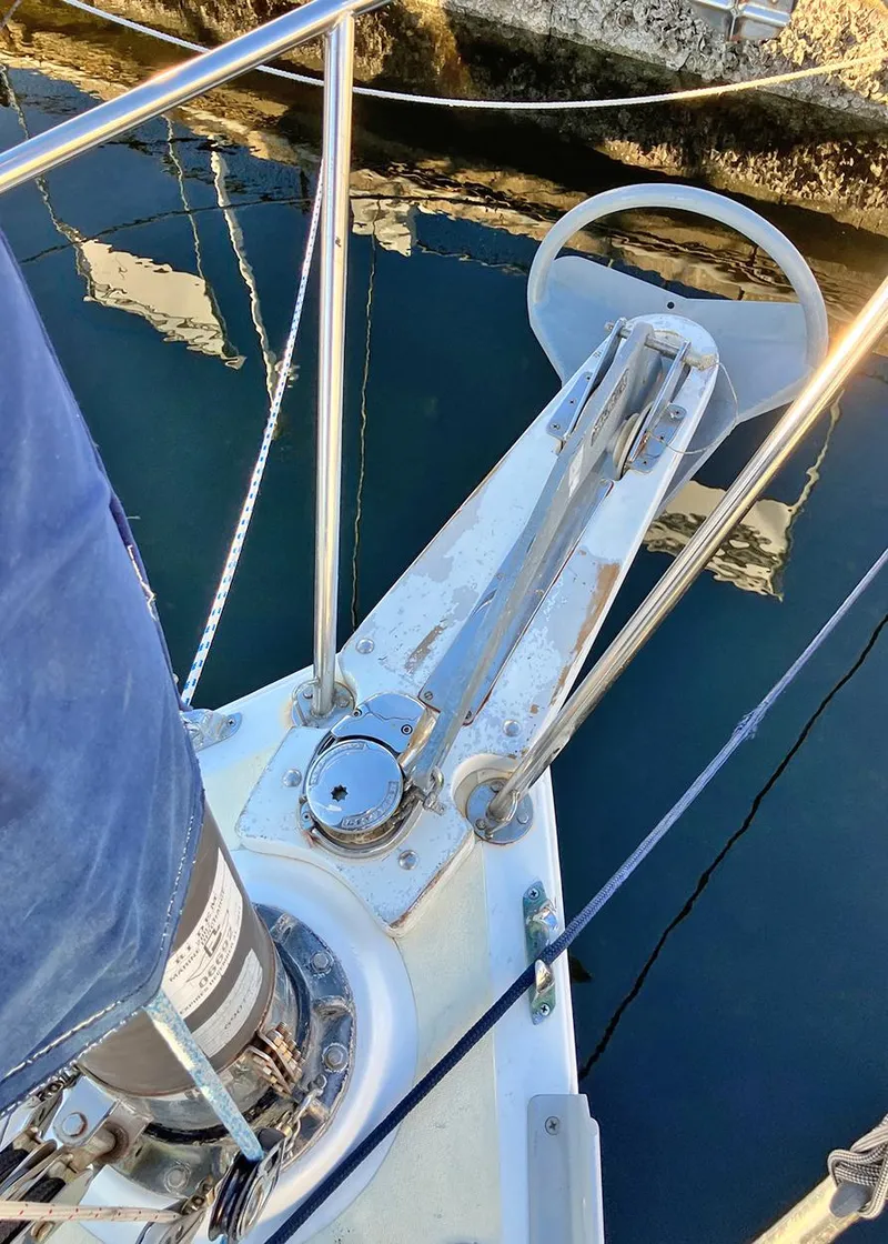 Slide: The Image of 1983 Freedom Cat Ketch sailboat anchor detail with calm water reflection. - 5