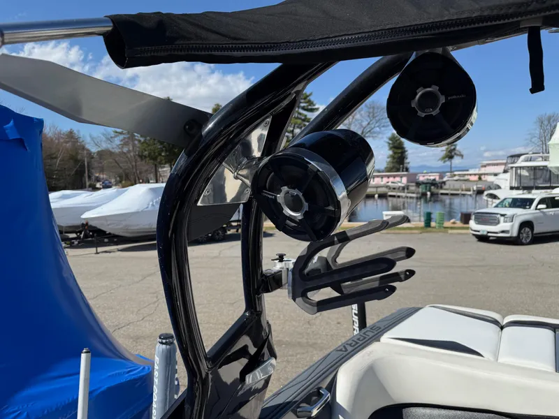 Slide: The Image of 2014 Supra Launch SC350-550 boat with speakers and wakeboard rack, docked outdoors. - 7