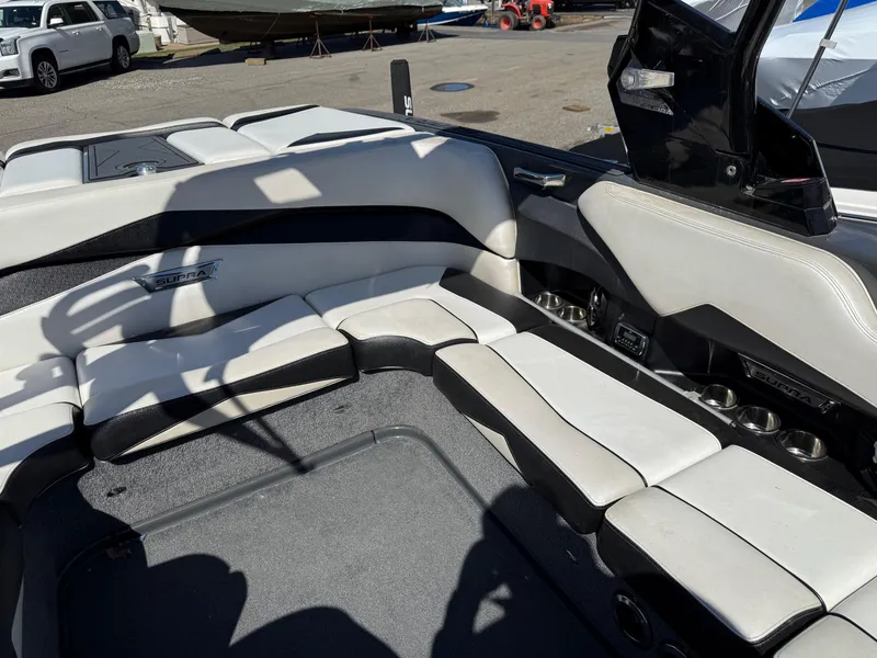 Slide: The Image of 2014 Supra Launch SC350-550 boat interior with white and black seating, docked outdoors. - 9