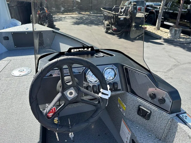 Slide: The Image of 2025 Lund 1675 Adventure SS boat dashboard with steering wheel and gauges. - 16