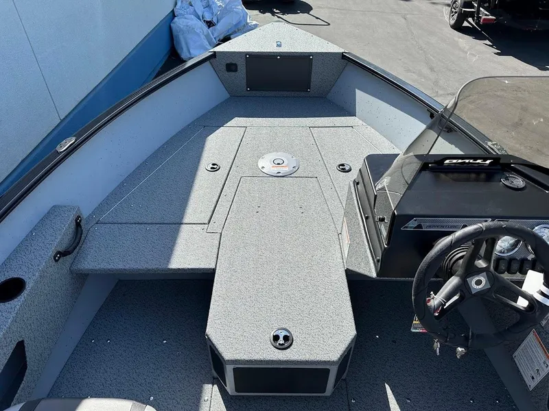 Slide: The Image of 2025 Lund 1675 Adventure SS boat interior with steering wheel and seating area. - 19