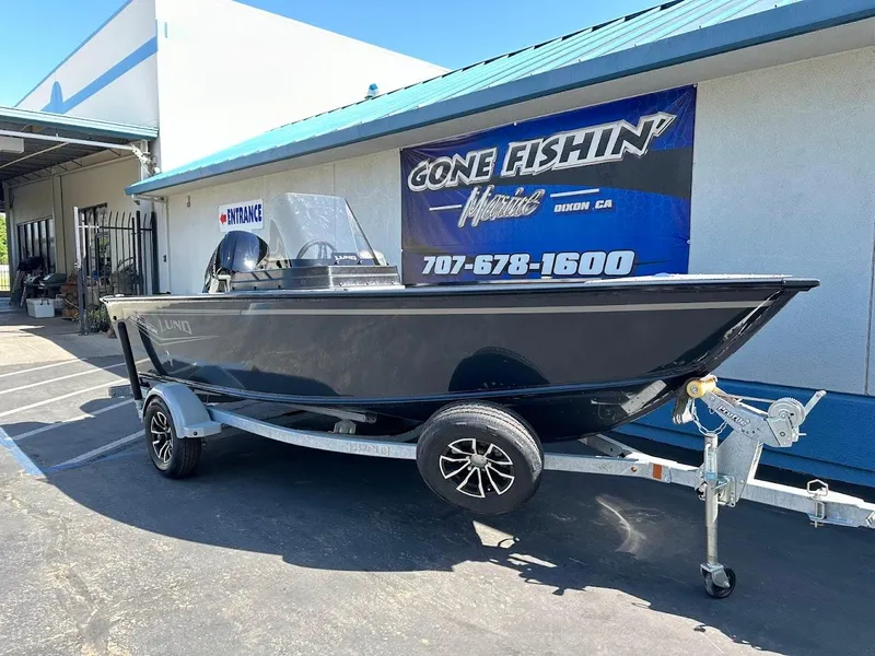 Slide: The Image of 2025 Lund 1675 Adventure SS boat on trailer outside dealership. - 2