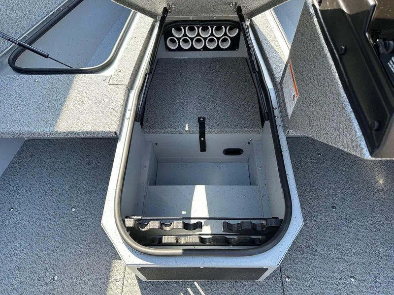 Slide: The Image of 2025 Lund 1675 Adventure SS boat storage compartment with rod holders, open hatch view. - 21