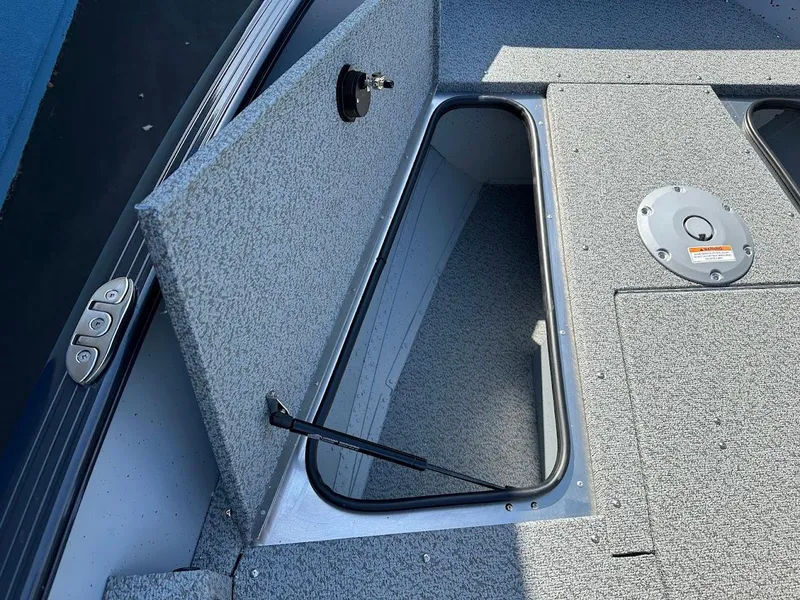 Slide: The Image of 2025 Lund 1675 Adventure SS boat storage compartment with open hatch, showcasing interior space. - 22