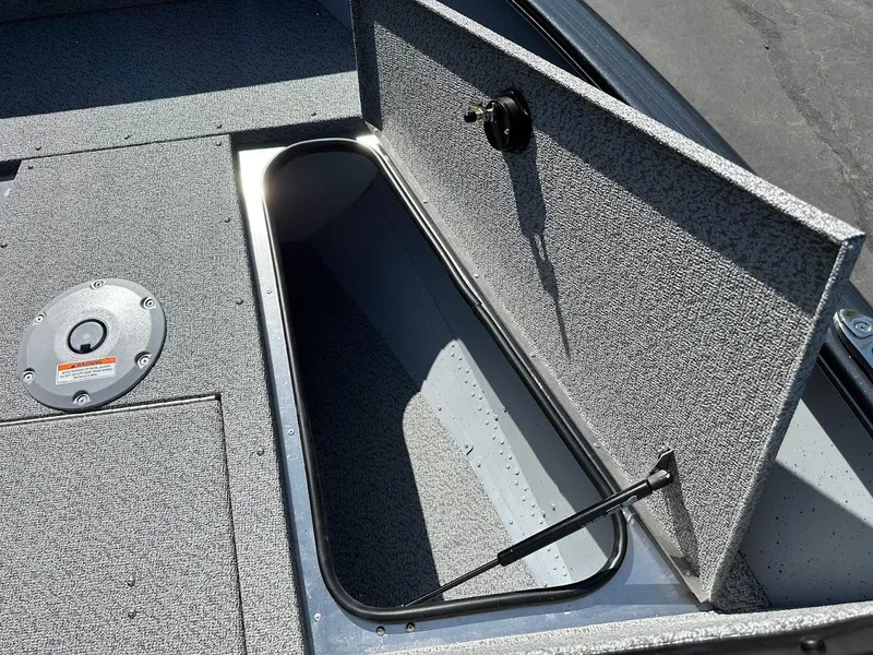 Slide: The Image of 2025 Lund 1675 Adventure SS boat storage compartment with open hatch, showcasing interior space. - 23
