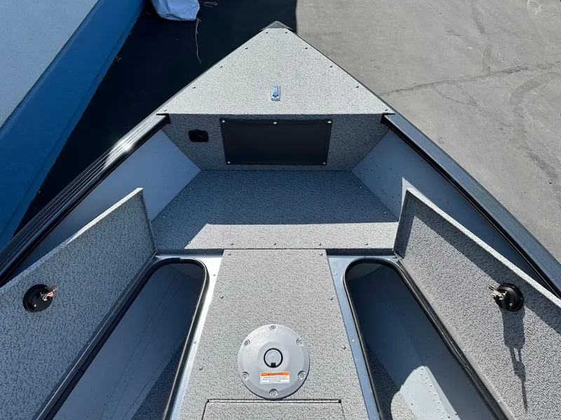 Slide: The Image of 2025 Lund 1675 Adventure SS boat interior with storage compartments and textured flooring. - 24