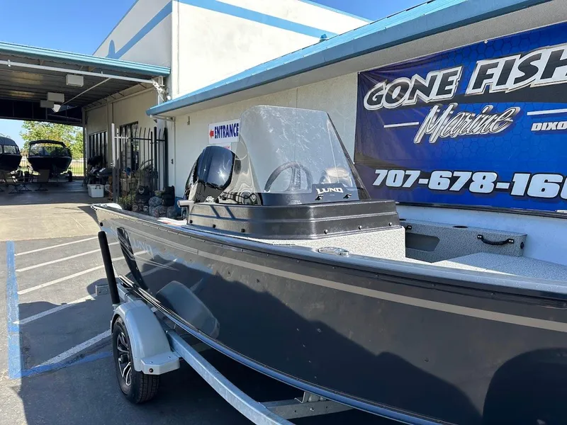 Slide: The Image of 2025 Lund 1675 Adventure SS boat on trailer outside marine shop. - 5