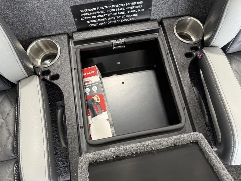 Slide: The Image of Interior storage compartment of 2025 Phoenix 920 Elite II with cup holders and safety warning. - 16