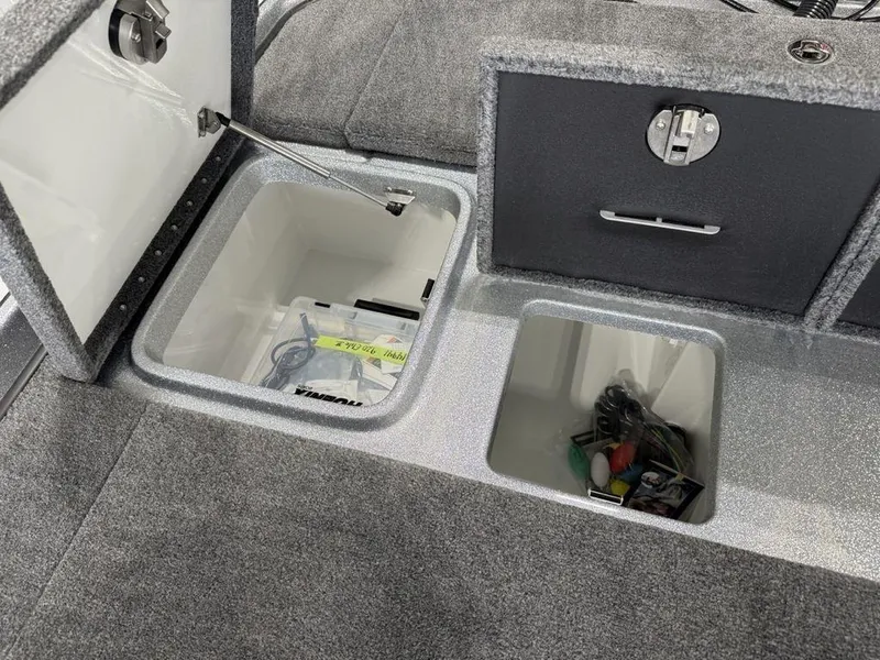 Slide: The Image of Open storage compartments in a 2025 Phoenix 920 Elite II boat interior. - 19