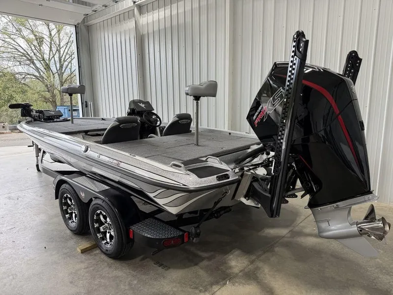 Slide: The Image of 2025 Phoenix 920 Elite II boat in garage, featuring dual seats and powerful outboard motor. - 3
