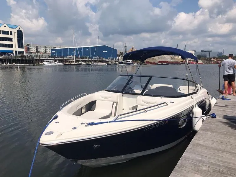 Slide: The Image of 2014 Chaparral 257 SSX boat docked at a marina under a partly cloudy sky. - 0