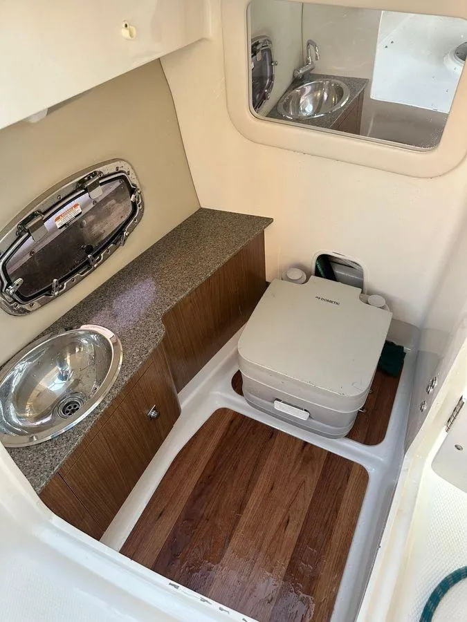 Slide: The Image of 2014 Chaparral 257 SSX boat interior with sink, countertop, and portable toilet. - 12