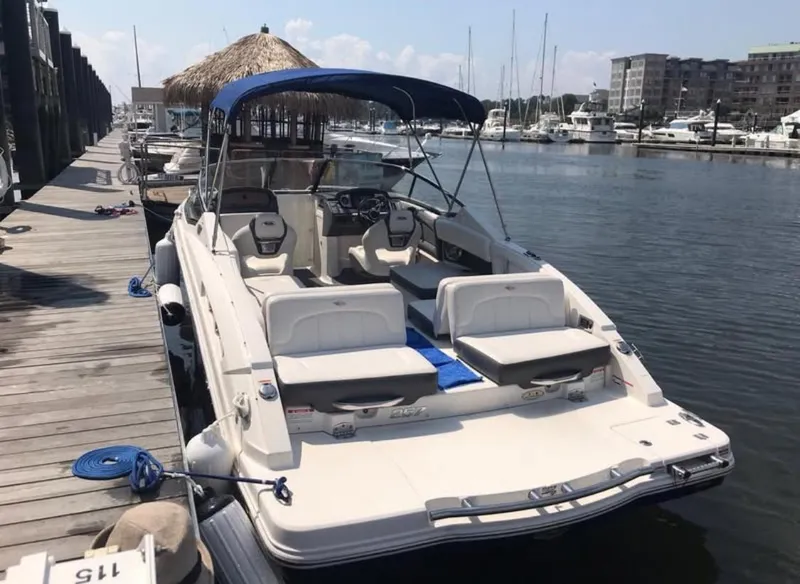Slide: The Image of 2014 Chaparral 257 SSX boat docked at marina with blue canopy. - 3