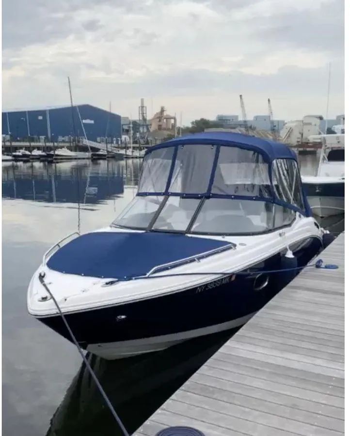 Slide: The Image of 2014 Chaparral 257 SSX boat docked at marina with blue canopy. - 4