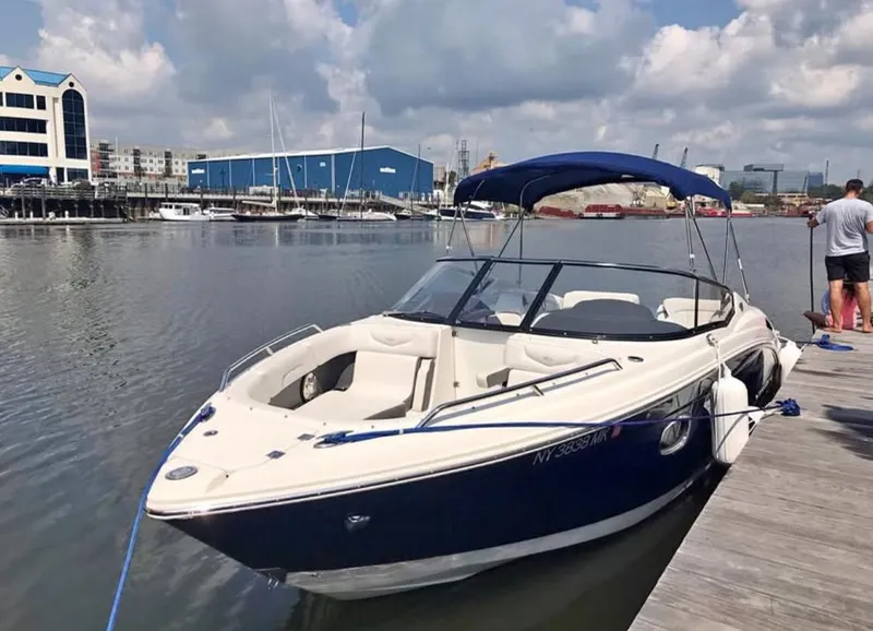 Slide: The Image of 2014 Chaparral 257 SSX boat docked at a marina under a blue sky. - 6