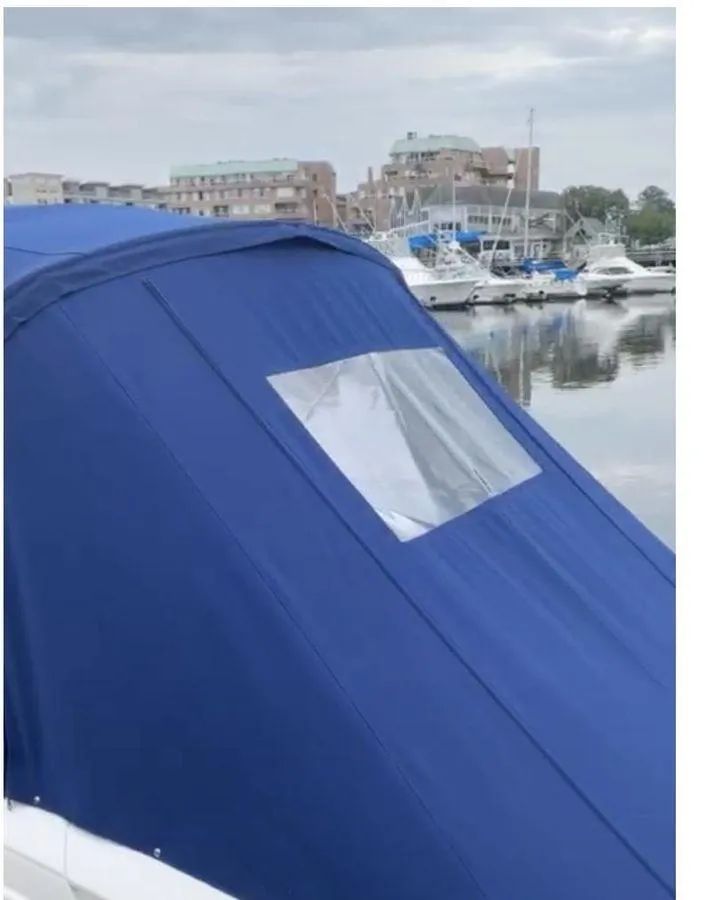 Slide: The Image of 2014 Chaparral 257 SSX boat with blue cover, docked in a marina. - 8