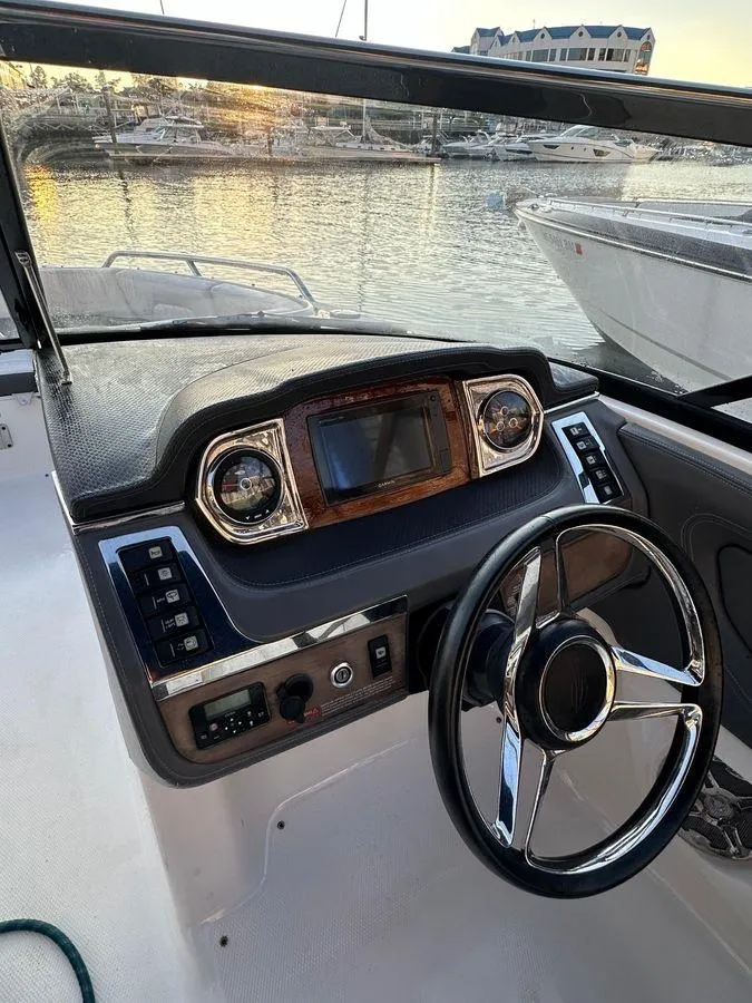Slide: The Image of 2014 Chaparral 257 SSX boat dashboard with steering wheel and control panel. - 9
