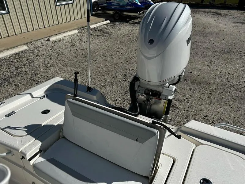 Slide: The Image of 2025 Skeeter SX221 boat with outboard motor, docked on gravel surface. - 12