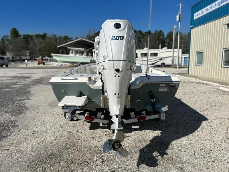 Slide: The Image of 2025 Skeeter SX221 boat with 200 HP outboard motor, parked outdoors. - 4