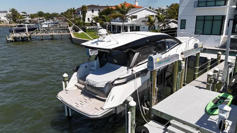 Slide: The Image of 2023 Beneteau Gran Turismo 45 yacht docked by waterfront homes. - 2