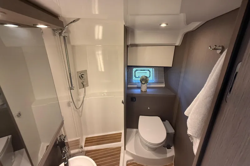 Slide: The Image of Modern bathroom in 2023 Beneteau Gran Turismo 45 yacht, featuring shower, toilet, and window. - 22