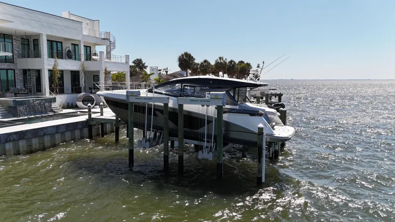 Slide: The Image of 2023 Beneteau Gran Turismo 45 yacht docked by a modern waterfront home. - 26