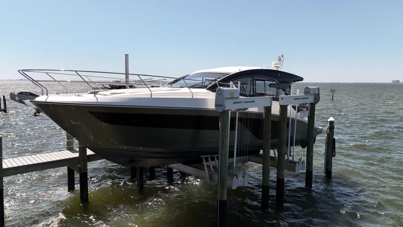 Slide: The Image of 2023 Beneteau Gran Turismo 45 yacht docked on a lift over water. - 28