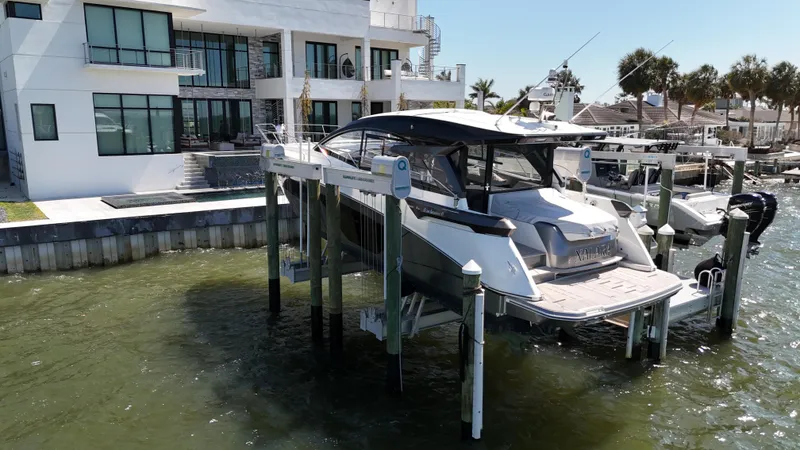 Slide: The Image of 2023 Beneteau Gran Turismo 45 yacht docked near modern waterfront home. - 3