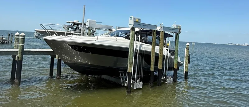 Slide: The Image of 2023 Beneteau Gran Turismo 45 yacht docked on a lift over calm water. - 4