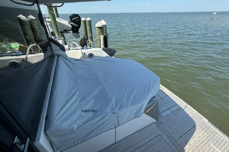 Slide: The Image of 2023 Beneteau Gran Turismo 45 yacht docked by the water, covered with a protective tarp. - 8