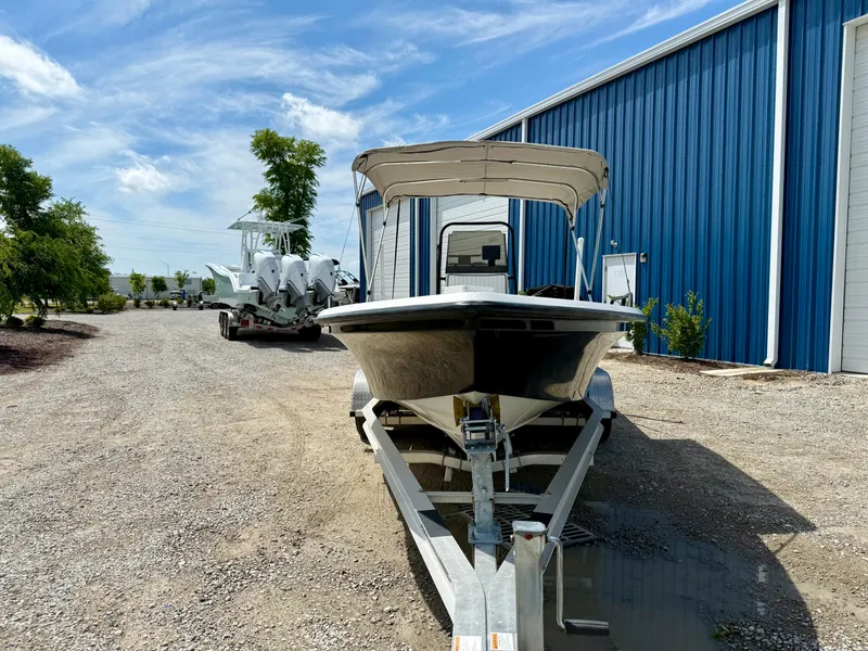 Slide: The Image of 2015 Stott Craft SCV 2160 Bay boat on trailer near blue building, sunny day. - 13