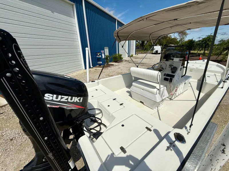 Slide: The Image of 2015 Stott Craft SCV 2160 Bay boat with Suzuki engine, parked near a blue building. - 16