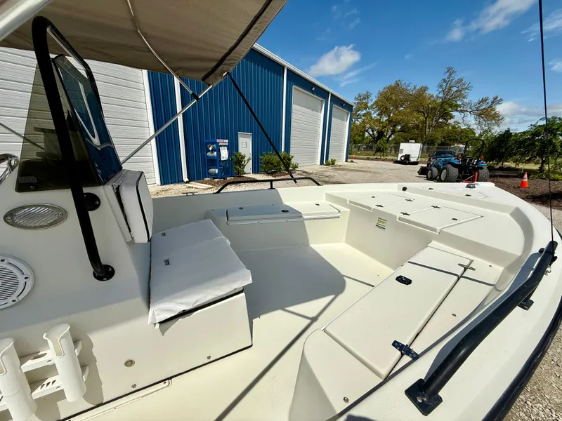 Slide: The Image of 2015 Stott Craft SCV 2160 Bay boat interior with seating, docked near blue building. - 20