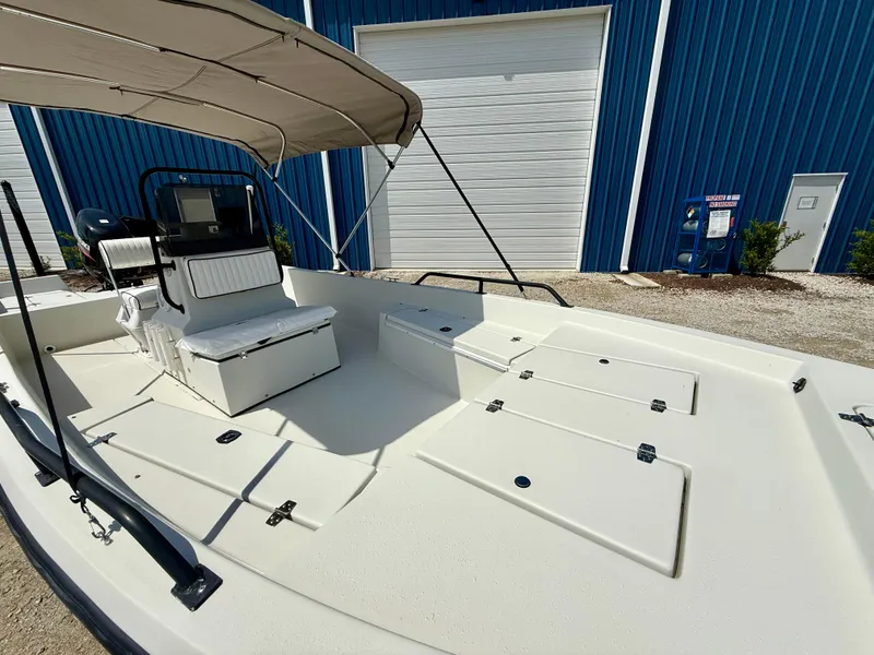 Slide: The Image of 2015 Stott Craft SCV 2160 Bay boat with canopy, docked near blue building. - 21