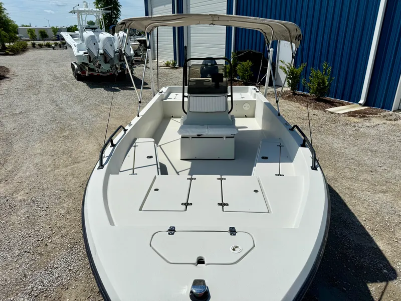 Slide: The Image of 2015 Stott Craft SCV 2160 Bay boat with canopy, parked on gravel near blue building. - 32