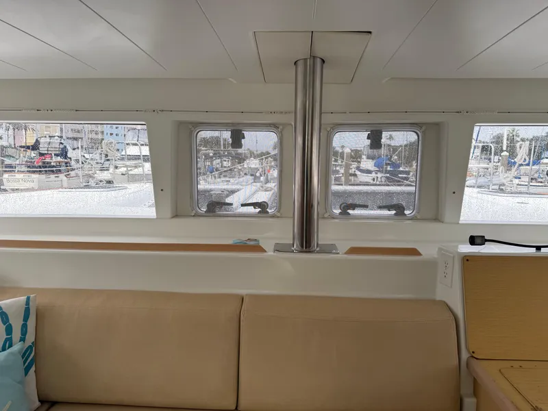 Slide: The Image of Interior view of 2010 Lagoon 400 catamaran, featuring beige seating and large windows. - 10