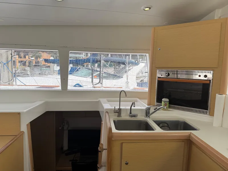 Slide: The Image of Interior of 2010 Lagoon 400 yacht kitchen with dual sinks and window view. - 16