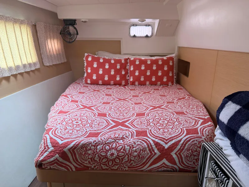 Slide: The Image of Cozy bedroom in 2010 Lagoon 400 yacht with red patterned bedding and nautical decor. - 26