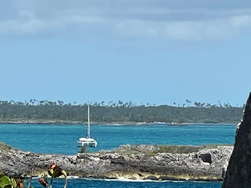 Slide: The Image of Sailboat on turquoise waters near rocky shore, Lagoon 400 Owner's Version, 2010 model. - 36