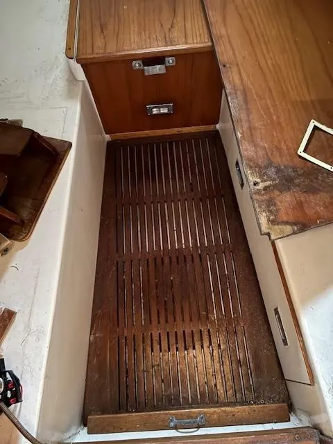 Slide: The Image of Wooden interior of 1990 Custom North End Composites Point boat, featuring slatted flooring and cabinetry. - 11