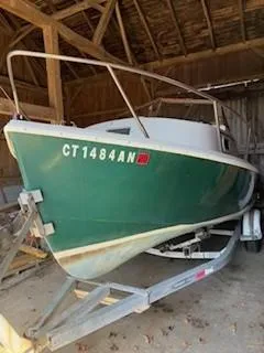 Slide: The Image of 1990 Custom North End Composites Point boat in a wooden shed on a trailer. - 14