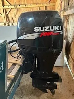 Slide: The Image of Suzuki outboard motor on 1990 Custom North End Composites Point boat in wooden shed. - 16