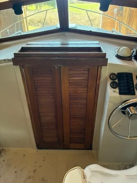 Slide: The Image of 1990 Custom North End Composites Point boat interior with wooden doors and steering wheel. - 4
