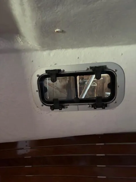 Slide: The Image of 1990 Custom North End Composites Point boat interior with a small rectangular window. - 8