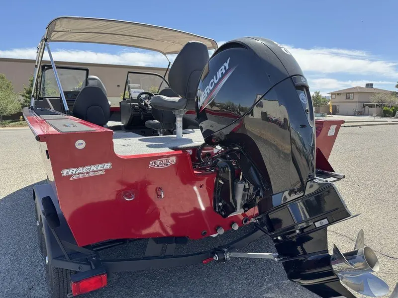 Slide: The Image of 2024 Tracker Targa™ V-18 Combo boat with Mercury engine, red exterior, parked outdoors. - 10